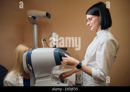 Die junge Augenärztin verwendet bei ihrer Arbeit spezielle Ausrüstung Stockfoto