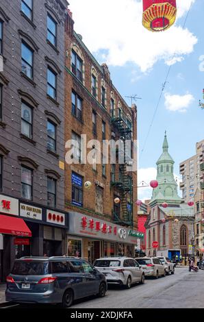 NYC Chinatown: Der Grüngris-farbene Glockenturm der Church of the Transfiguration, ein Wahrzeichen von NYC, befindet sich an der Ecke der Mott Street. Stockfoto