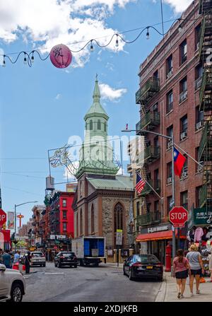 NYC Chinatown: Der Grüngris-farbene Glockenturm der Church of the Transfiguration, ein Wahrzeichen von NYC, befindet sich an der Ecke der Mott Street. Stockfoto