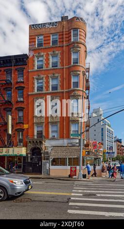 Kunstvoll verzierte Terrakotta-Spandrels und Fenster zieren dieses mittelhohe Apartment-Gebäude aus rotem Backstein in der Lower East Side von New York City. Stockfoto