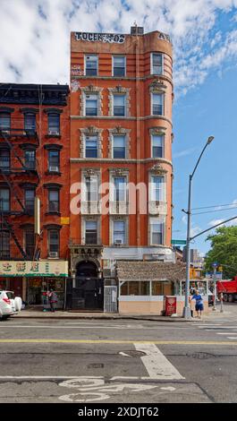 Kunstvoll verzierte Terrakotta-Spandrels und Fenster zieren dieses mittelhohe Apartment-Gebäude aus rotem Backstein in der Lower East Side von New York City. Stockfoto