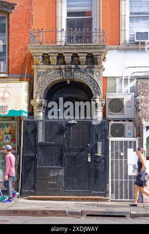 Kunstvoll verzierte Terrakotta-Spandrels und Fenster zieren dieses mittelhohe Apartment-Gebäude aus rotem Backstein in der Lower East Side von New York City. Stockfoto