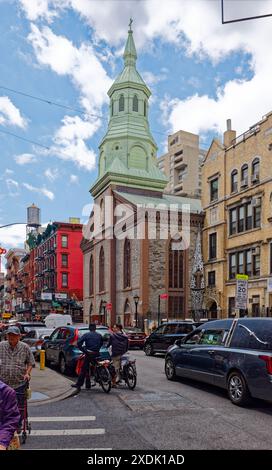 NYC Chinatown: Der Grüngris-farbene Glockenturm der Church of the Transfiguration, ein Wahrzeichen von NYC, befindet sich an der Ecke der Mott Street. Stockfoto