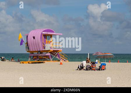 Miami, Florida, USA - 5. Dezember 2023: Rettungshütte am Miami South Beach mit Besuchern, die auf dem Sand sitzen Stockfoto