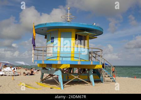 Miami, Florida, USA - 5. Dezember 2023: Rettungshütte am Miami South Beach mit Besuchern, die auf dem Sand sitzen Stockfoto