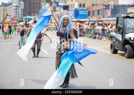 New York, USA. Juni 2024. Ein Teilnehmer der 42. Jährlichen Meerjungfrauenparade auf Coney Island in New York, NY, tritt am 22. Juni 2024 in der Straße in Kostümen auf. Seit 1983 sind Hunderttausende von New Yorkern und Besuchern gekommen, um an dieser Parade teilzunehmen, die von den Coney Island Mardi Gras-Paraden der Vergangenheit inspiriert wurde. Ähnlich wie in den vergangenen Jahren gab es in diesem Jahr eine große Auswahl an festlichen Kostümen, Make-up, Wagen, Bannern, Musik, und vieles mehr. (Foto: Hailstorm Visuals/SIPA USA) Credit: SIPA USA/Alamy Live News Stockfoto