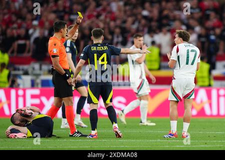 Der ungarische Callum Styles (rechts) wird von Schiedsrichter Facundo Tello nach einem Foul gegen John McGinn (links) während des UEFA Euro 2024 Gruppenspiels A in der Stuttgart Arena in Stuttgart eine gelbe Karte gezeigt. Bilddatum: Sonntag, 23. Juni 2024. Stockfoto