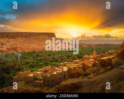 Erleben Sie den atemberaubenden Sonnenuntergang über einem Berberdorf im Dades-Tal, Tinghir, Marokko. Dieser malerische Blick auf die Todra-Schlucht fängt das Wesen der Tradition ein Stockfoto