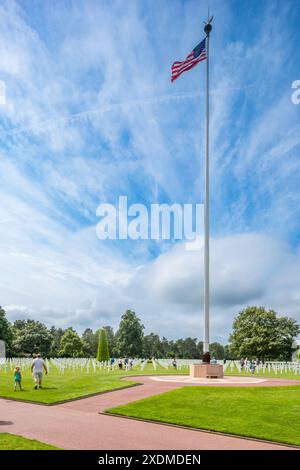 Amerikanischer Militärfriedhof in der Normandie, Frankreich, mit Reihen weißer Kreuze und einem hohen Fahnenmast mit der US-Flagge. Eine friedliche Umgebung zu Ehren des Sturzes Stockfoto