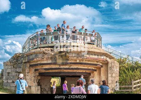 Eine Gruppe von Touristen erkundet einen historischen deutschen Bunker in Pointe du hoc in der Normandie, Frankreich. Malerische Aussicht und historische Atmosphäre. Stockfoto