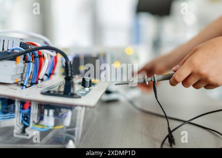 Auf der Leiterplatte arbeiten, Roboter im Robotik-Club der Schule bauen. Kinder, die Robotik in der Grundschule lernen. Stockfoto