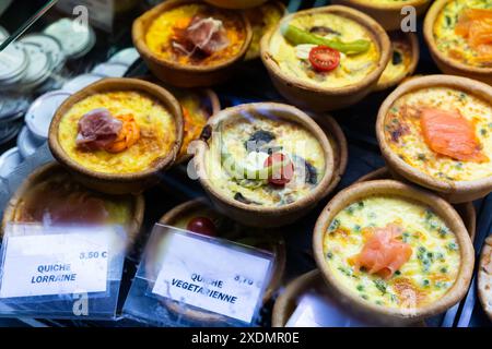 Französische Quiches im Sortiment am Marktschalter Stockfoto