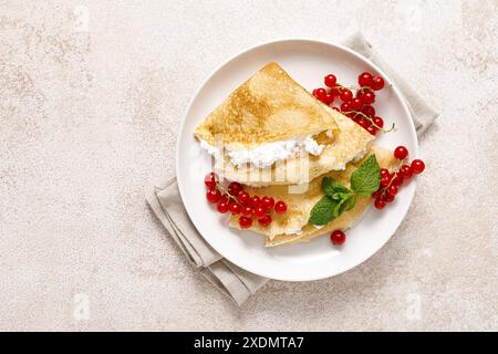 Crepes oder dünne Pfannkuchen mit Käsehütte oder Quark und frischen roten Johannisbeerbeeren, Blick von oben Stockfoto