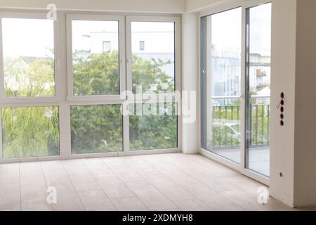 Leeres Zimmer in neuem Gebäude mit unvollendeter Renovierung und großen Fenstern Stockfoto