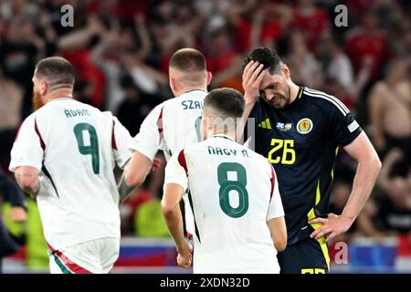 Stuttgart, Deutschland. Juni 2024. Fußball, UEFA Euro 2024, Europameisterschaft, Schottland - Ungarn, Vorrunde, Gruppe A, Spieltag 3, Stuttgart Arena, während die ungarischen Spieler jubeln, der schottische Scott McKenna (r) enttäuscht reagiert. Quelle: Marijan Murat/dpa/Alamy Live News Stockfoto