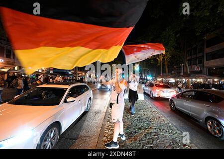 Köln, Deutschland. Juni 2024. Fußball: Europameisterschaft, öffentliche Sicht Schweiz - Deutschland. Die Fans schwenkten nach dem letzten Gruppenspiel der deutschen Mannschaft während einer Autokolonne Fahnen. Quelle: Roberto Pfeil/dpa/Alamy Live News Stockfoto