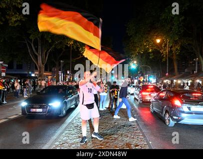 Köln, Deutschland. Juni 2024. Fußball: Europameisterschaft, öffentliche Sicht Schweiz - Deutschland. Die Fans schwenkten nach dem letzten Gruppenspiel der deutschen Mannschaft während einer Autokolonne Fahnen. Quelle: Roberto Pfeil/dpa/Alamy Live News Stockfoto