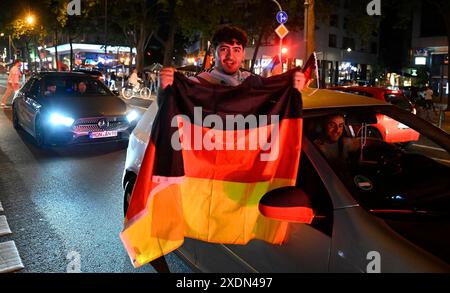 Köln, Deutschland. Juni 2024. Fußball: Europameisterschaft, öffentliche Sicht Schweiz - Deutschland. Die Fans schwenkten nach dem letzten Gruppenspiel der deutschen Mannschaft während einer Autokolonne Fahnen. Quelle: Roberto Pfeil/dpa/Alamy Live News Stockfoto