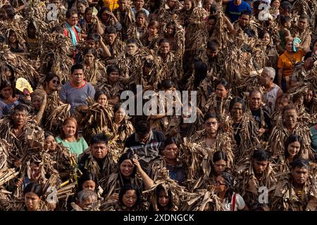 Manila, Manila, Philippinen. Juni 2024. Anhänger zünden Kerzen an, während sie am Taong Putik (menschlicher Schlamm) teilnehmen Festival, indem sie ihre Körper mit Schlamm bedecken und sich mit Bananenblättern mit Schlamm verkleiden, um den Heiligen Johannes den Täufer zu ehren und vom Priester gesegnet während einer Messe vor der Pfarrkirche Saint John the Baptist während des Taong Putik Festivals in Brgy. Quelle: ZUMA Press, Inc./Alamy Live News Stockfoto