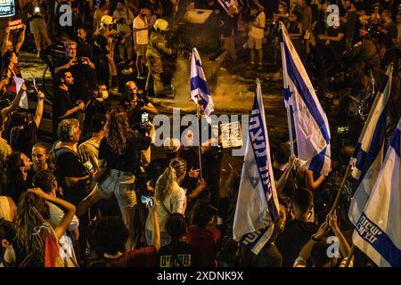 Tel Aviv, Israel. Juni 2024. Ein israelischer Polizist schiebt während der Demonstration einen Demonstranten mit einem Schild mit der Aufschrift "Stop the war". Über 100.000 Israelis demonstrierten in Kaplan mit den Familien der Geiseln gegen Premierminister Benjamin Netanjahu und forderten einen sofortigen Geiselvertrag und Waffenstillstand, nachdem die Demonstranten ein Lagerfeuer vor dem historischen Hauptquartier der Likud-Partei „Metzudat Ze'ev“ errichtet hatten, was zu Konflikten mit der israelischen Polizei führte. Quelle: SOPA Images Limited/Alamy Live News Stockfoto