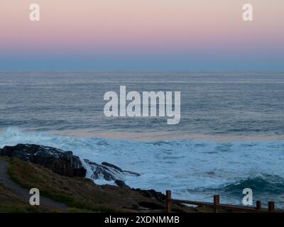 Herrlicher rosa und blauer Sonnenuntergang, der sich in Wolken im Osten über dem Pazifik spiegelt, NSW Australien Stockfoto