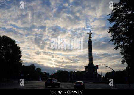 Berlin, Deutschland. Juni 2024. Die aufgehende Sonne erleuchtet die Wolken über der Siegessäule. Laut Wettervorhersage beginnt die Woche mit Hochsommertemperaturen. Annette Riedl/dpa/Alamy Live News Stockfoto