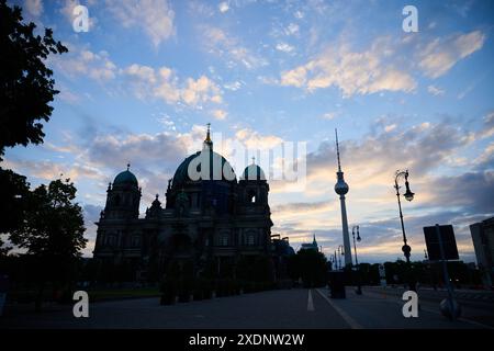 Berlin, Deutschland. Juni 2024. Die aufgehende Sonne erleuchtet die Wolken über dem Berliner Dom und dem Fernsehturm. Laut Wettervorhersage beginnt die Woche mit Hochsommertemperaturen. Annette Riedl/dpa/Alamy Live News Stockfoto
