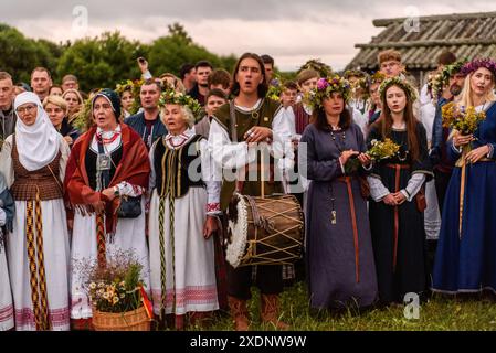 In traditioneller litauischer Kleidung singen Menschen bei der Feier des Johannisfeiertags und der Sommersonnenwende in der kleinen Stadt Kernave, etwa 40 km von Vilnius entfernt. Jonin?s, auch bekannt als St. John's Day oder Rasos, ist ein traditionelles Mittsommerfest, das in Litauen gefeiert wird. Es findet um die Sommersonnenwende statt, typischerweise in der Nacht vom 23. Auf den 24. Juni. Das fest ist tief in heidnischen Traditionen verwurzelt und ist eines der bedeutendsten und beliebtesten Feierlichkeiten in Litauen. Stockfoto