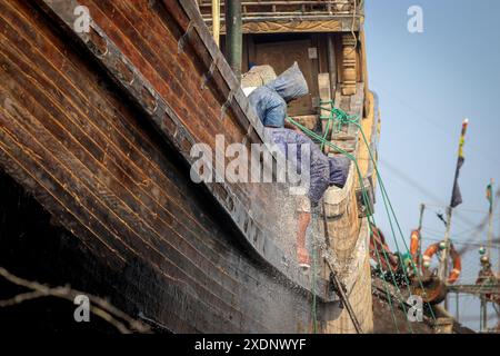 Arbeiter, der ein Fischerboot wäscht. Dieses Foto wurde aus Chittagong, Bangladesch, aufgenommen. Stockfoto