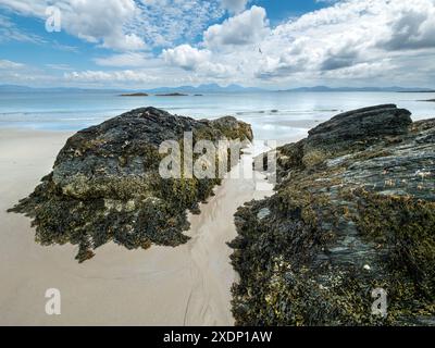 Der Paps of Jura ist am Horizont vom Port A Chapuill Strand auf der nahegelegenen Insel Colonsay in den Inneren Hebriden in Schottland, Großbritannien, zu sehen Stockfoto