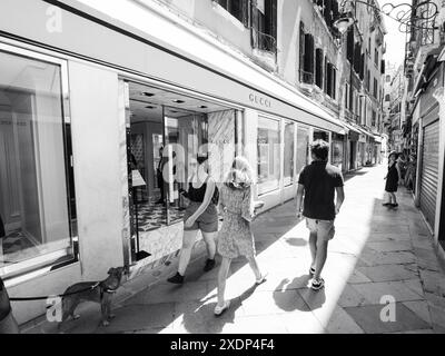 Venedig, Italien - 30. Juni 20220 Touristen, die eine enge Straße mit Luxusgeschäften und Restaurants in venedig, italien, hinunterlaufen Stockfoto