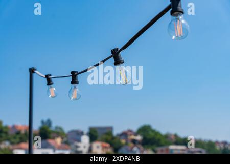 Glühbirnen vor einem Hintergrund von klarem blauem Himmel und Horizont mit Prager Häusern an einem sonnigen Tag Stockfoto
