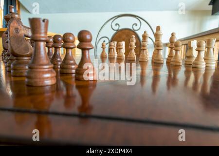 Nahaufnahme von hölzernen Schachfiguren auf einem Schachbrett, bereit für ein Spiel Stockfoto
