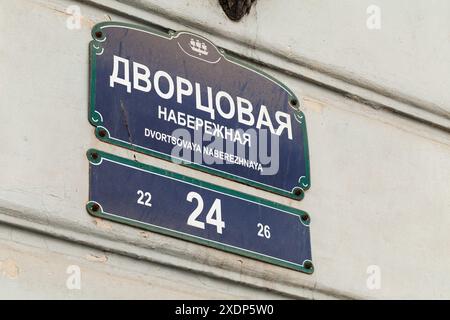 Sankt Petersburg, Russland - 3. März 2019: Straßenschild am Palaststeg von Sankt Petersburg mit englischer Übersetzung. Blaue Platten auf gelb montiert Stockfoto