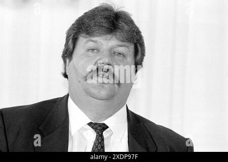 Heinz Weifenbach Praesident des Eishockeyvereins ECD Iserlohn presentiert *das grüne Buch* des lybischen Revolutionsführers Muammar Al-Ghaddafi, mit dem der Eishockeyverein ECD Iserlohn während eines Eishockeyspiels als Werbung auf den Trikots auflief. März 1988 in Iserlohn, Deutschland *** Heinz Weifenbach Präsident des Eishockeyvereins ECD Iserlohn präsentiert das Grünbuch des libyschen Revolutionsführers Muammar Al Ghaddafi, mit dem der Eishockeyverein ECD Iserlohn während eines Eishockeyspiels im März 1988 in Iserlohn als Werbung auf den Trikots erschien Stockfoto