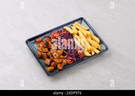 Frisch gebackene Pommes Frites mit Cheddar Käse, Speck und Petersilie closeup auf einer Platte gekocht. horizontal oben Ansicht von oben Stockfoto