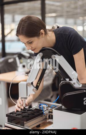 Ingenieurinnen lernen Ausbildung im industriellen Robotik-Programm mit Roboterarm-Simulationsmodell im Techniklabor der Universität. Stockfoto