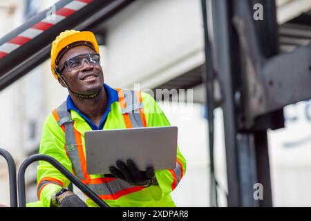 Porträt glücklicher afrikanischer schwarzer Arbeiter in der Frachtschifffahrtsindustrie mit Schutzweste. Foreman oder Supervisor im Container Ship Yard Terminal. Stockfoto