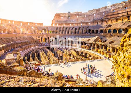 Ein malerischer Blick auf das Kolosseum in Rom, Italien, bei Sonnenuntergang. Das antike Amphitheater ist in goldenes Licht getaucht, mit Menschenmassen, die den warmen Abend genießen. Stockfoto
