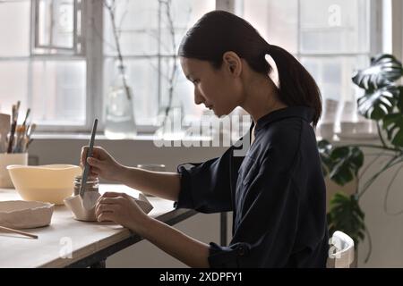 Asiatische Künstler glasieren und malen Tongeschirr mit Pinsel Stockfoto