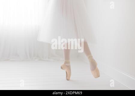 Ballerinas Füße im ätherischen weißen Studio en pointe Stockfoto