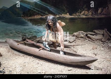 Ein Diorama des Maori-Lebens im Canterbury Museum, das eine Frau mit einem Kanu zeigt. Körniges Bild, das bei verfügbarem Licht aufgenommen wird. Stockfoto