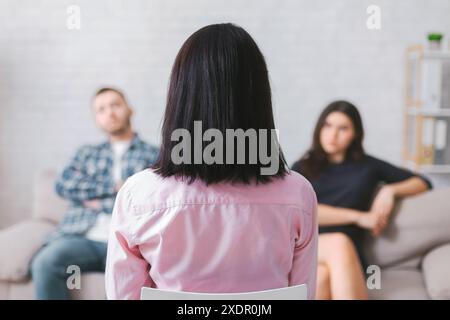 Frau, die ein Paar während der Therapiesitzung im Wohnzimmer hört Stockfoto