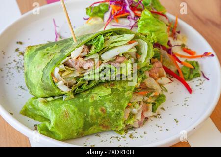 Gesunde grüne Wraps in einer Café-Umgebung serviert auf einem Teller. Stockfoto