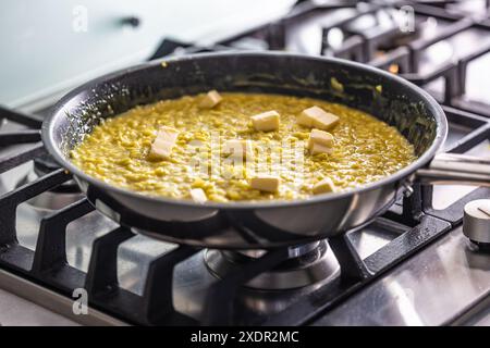 Ein Teil der Herstellung von Risotto ist das Hinzufügen von Butter am Ende Stockfoto