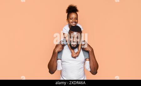 Liebevoller Vater Und Tochter Genießen Spielerische Momente Vor Pfirsichhintergrund Stockfoto