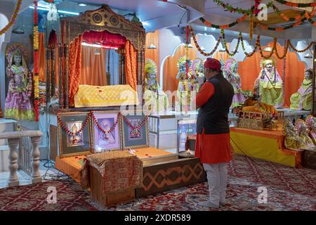 Ein hinduistischer Priester liest persönliche Nachrichten bei einem Gottesdienst im Satya Narayan Mandir in Woodside, Queens, New York. Stockfoto