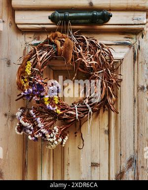 Kranz aus getrockneten Blumen hängt an einer antiken Holztür, Stadt Nafplio, Pelopones, Griechenland, griechische Inseln, Europa Stockfoto