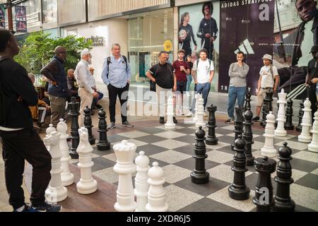 Männer spielen riesige Schachfiguren im Westfield Einkaufszentrum, Stratford, East London, England, Großbritannien Stockfoto