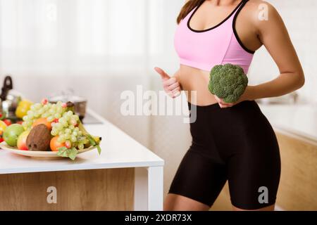 Frau, die Brokkoli in der Küche hält Stockfoto